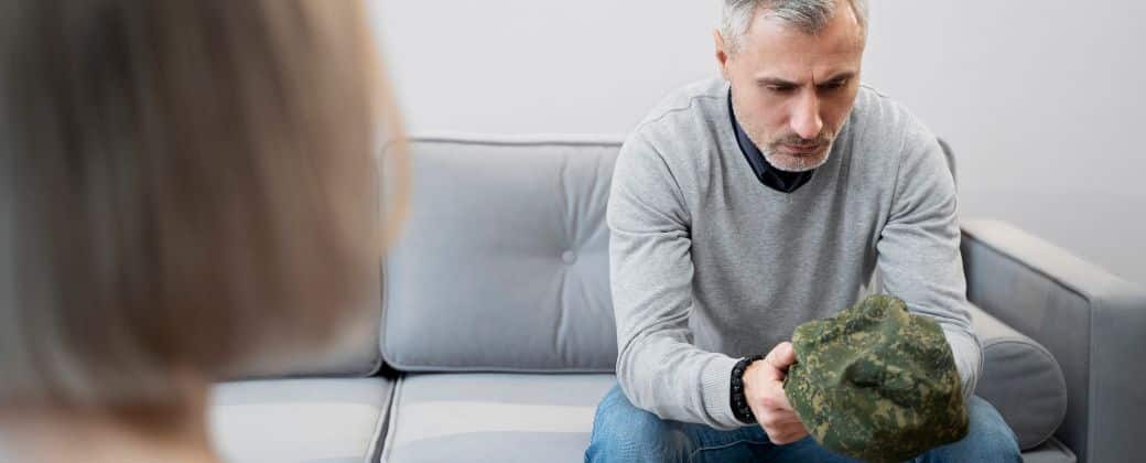 גבר עם שיער לבן יושב על הספה מול המטפלת שמעבירה טיפול CBT